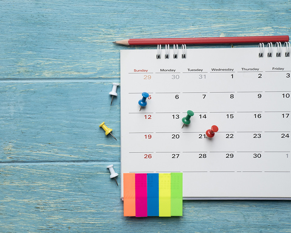 La imagen muestra un calendario con elementos como chinchetas o adhesivos